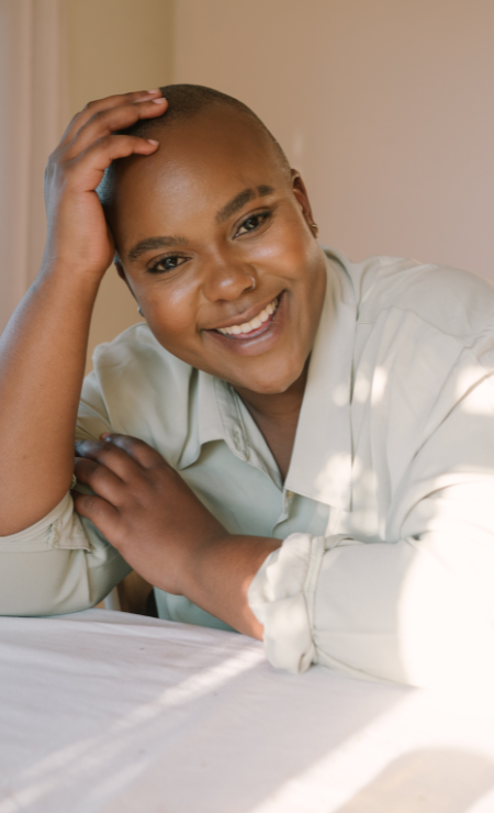 Happy black woman with Alopecia that started to receive treatment with a Trichologist in Brampton