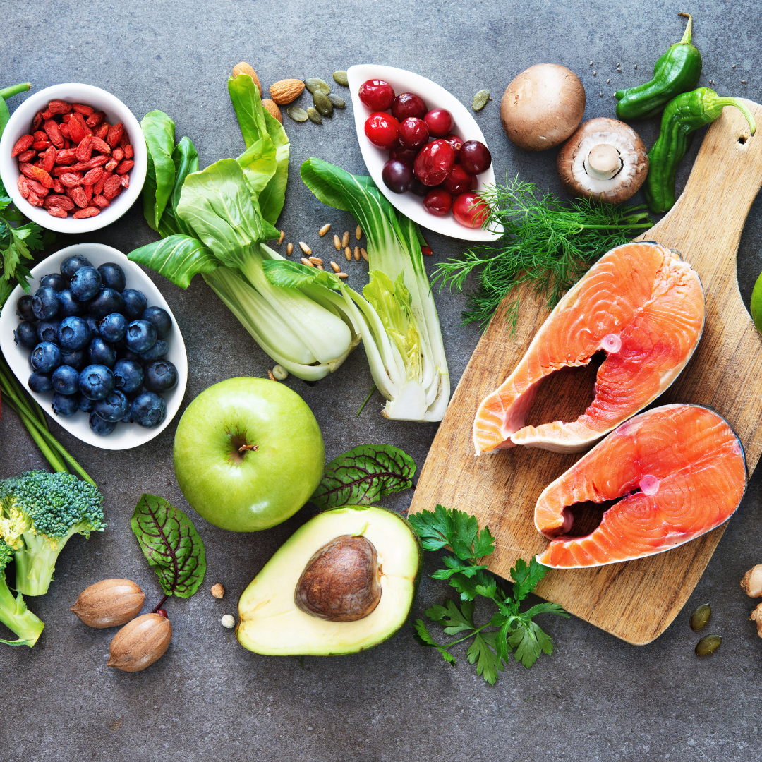 Promotional image for Alopecia & Beyond's blog post dated March 18, 2024, with the title Best Foods for Hair Growth: Nourish Your Locks from Within. The photo displays a vibrant selection of nutritious foods including salmon, avocado, berries, and greens, symbolizing a diet beneficial for hair health.